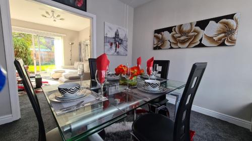 a dining room with a glass table and chairs at Stunning Holiday Home. Free Parking. in Manchester