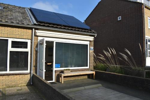 une fenêtre avec un panneau solaire sur le côté d'une maison dans l'établissement ZeeBedStay, à Noordwijk aan Zee