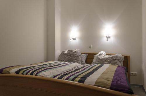 a bed in a room with two lights on the wall at Ferienwohnung Radebeul Gerlach in Radebeul