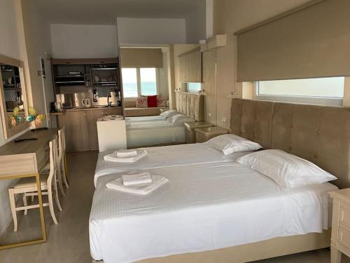 1 dormitorio con 1 cama blanca grande y cocina en see the sea1, en Kassiopi