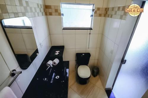 a small bathroom with a toilet and a sink at Pousada Sol e Cia Tur in Caraguatatuba