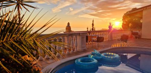 une piscine avec vue sur le coucher du soleil en arrière-plan dans l'établissement Ashram Villa Sunshine, à Sitges