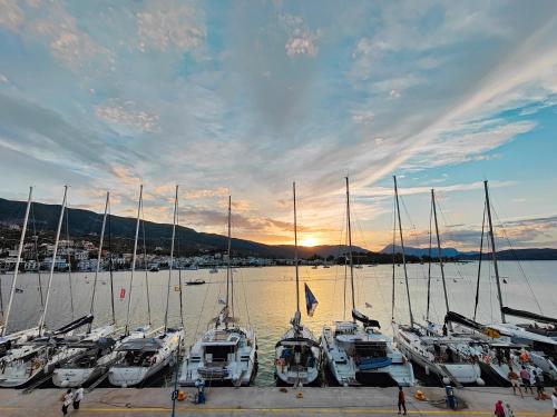 eine Gruppe von Booten, die bei Sonnenuntergang in einem Yachthafen angedockt sind in der Unterkunft The Manessi City Boutique Hotel in Poros