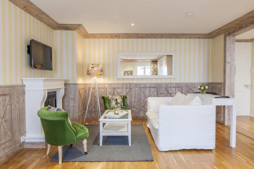 a living room with a white couch and a fireplace at Hotel & Restaurant Sonne in Kirchzarten