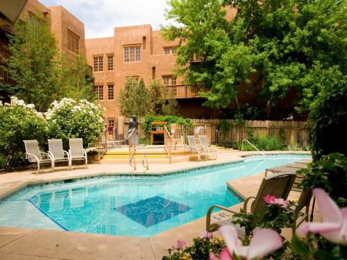 una piscina con sillas y un edificio en Hotel Santa Fe, en Santa Fe