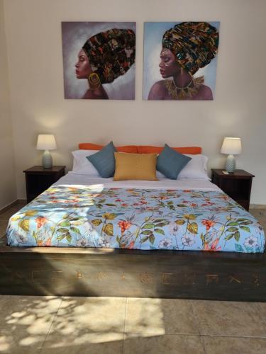 ein Bett in einem Schlafzimmer mit zwei Bildern an der Wand in der Unterkunft Pool House with Shared Pool Access in David