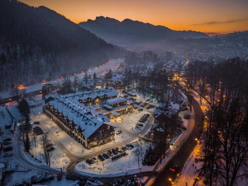 Blick auf eine Stadt im Schnee in der Nacht in der Unterkunft Szczawnica Park Resort & Spa in Szczawnica