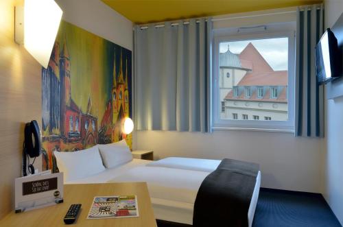 um quarto de hotel com uma cama e uma janela em B&B HOTEL Erfurt-Hbf em Erfurt