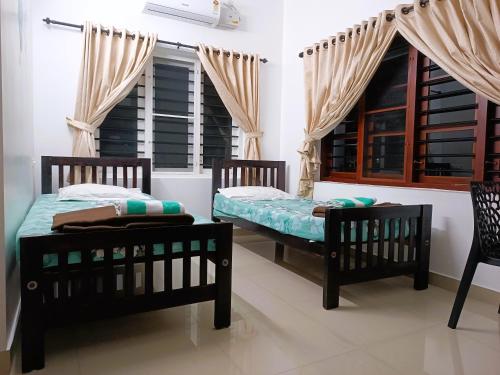 PRAKRITI HOMESTAY Fortkochi Air Conditioned Rooms tesisinde bir odada yatak veya yataklar