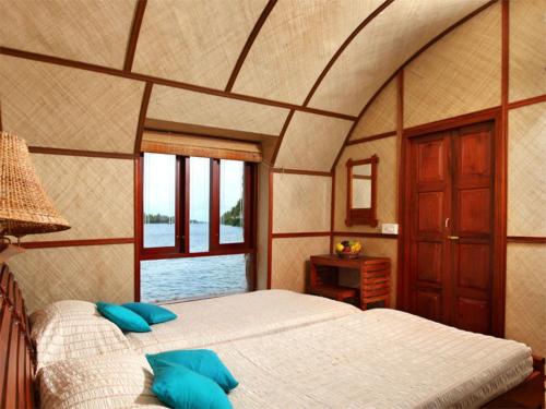 una camera da letto con un grande letto con cuscini blu di Marvel Cruise a Alleppey