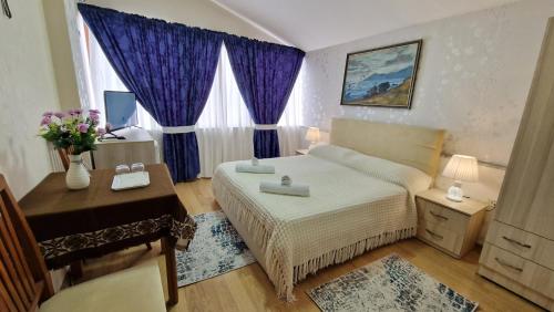 1 dormitorio con cama, escritorio y ventana en Vila Korani, en Tirana