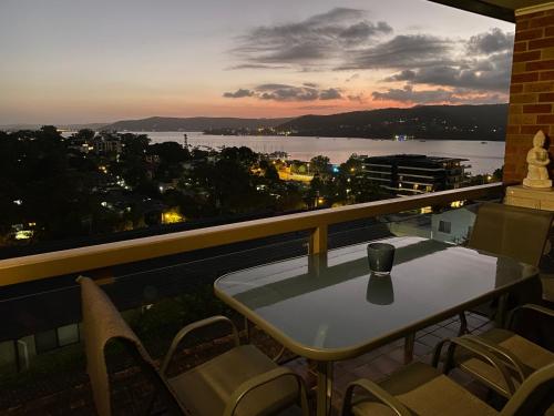 einen Tisch und Stühle auf einem Balkon mit Aussicht in der Unterkunft Gosfords Best Location with Views in Gosford