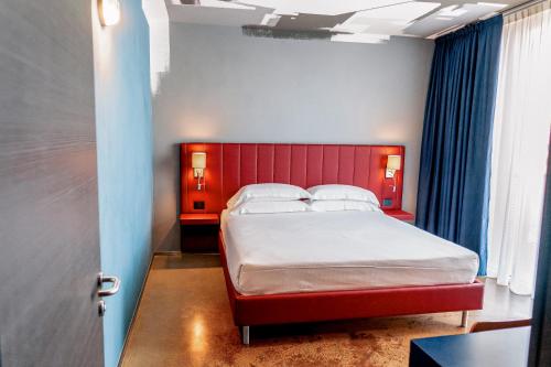 een slaapkamer met een groot bed met een rood hoofdeinde bij K MODERN HOTEL in Peschiera del Garda