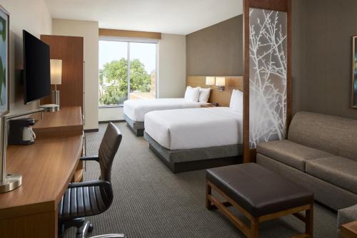 une chambre d'hôtel avec deux lits et un canapé dans l'établissement Hyatt Place Evansville, à Evansville