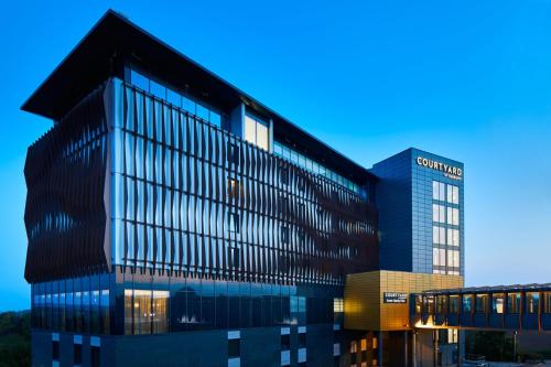 een groot gebouw met veel ramen bij Courtyard by Marriott Exeter Sandy Park in Exeter