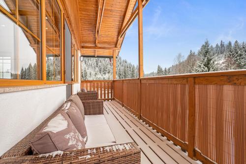 a screened in porch with a couch on a deck at Apartmán Ela in Horní Blatná