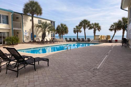 una piscina con sillas y el océano en el fondo en The Oceanfront Litchfield Inn 251, en Pawleys Island