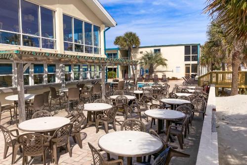 un patio con mesas y sillas frente a un edificio en The Oceanfront Litchfield Inn 251, en Pawleys Island