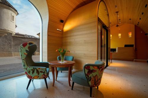 a room with two chairs and a table and a mirror at Hotel La Briosa in Bolzano