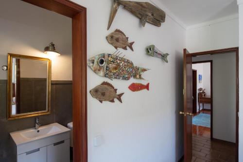 een badkamer met visdecoraties aan de muur bij Moby Dick Lodge in Malveira da Serra