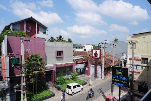 een straat met een wit busje voor een gebouw bij UK Inn Guest House in Jaffna