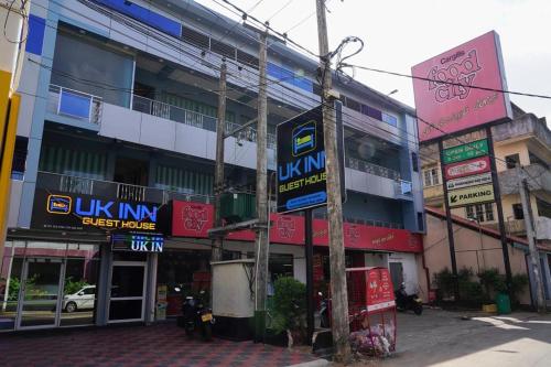 een gebouw met borden aan de straatkant bij UK Inn Guest House in Jaffna