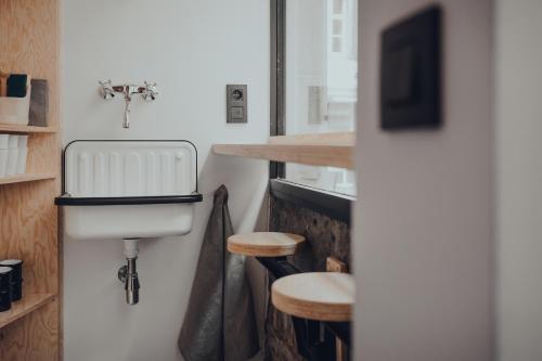 een badkamer met een toilet en een aanrecht met krukken bij Cabane Urbaine 1 - centre in Namen