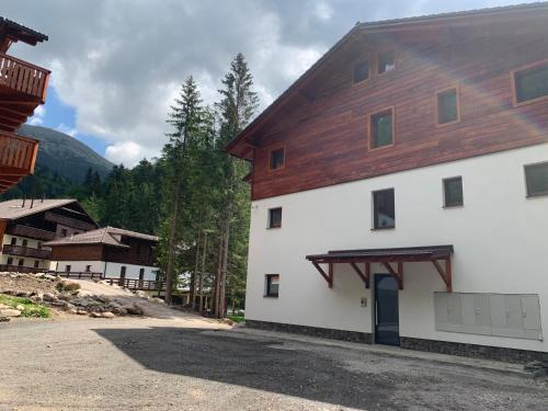 a large white building with a wooden roof at Apartmán Jeleň Chopok Juh-Trangoška in Tale