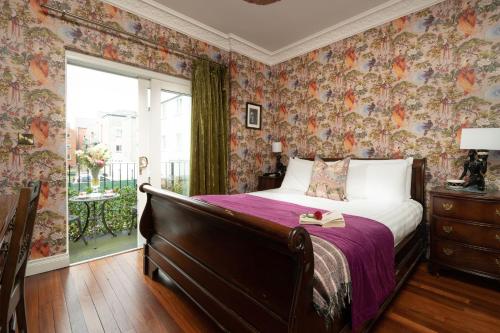 una camera da letto con un letto con carta da parati floreale di The Harrison Chambers of Distinction a Belfast