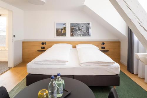 um quarto com uma cama e uma mesa com garrafas em Fred Hotel Zürich Hauptbahnhof em Zurique