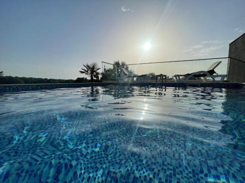 ein Pool mit Sonnenuntergang im Hintergrund in der Unterkunft AM Palace in Ulcinj