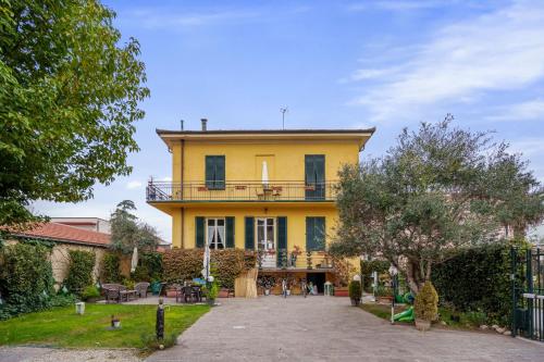 een geel huis met een balkon erboven bij Villa San Donato B&B in Lucca