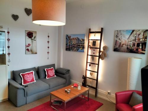 uma sala de estar com um sofá e uma mesa em Coeur d'Elsass "RAPP"appartement avec parking em Colmar