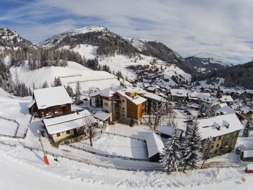 a ski resort with snow covered buildings and mountains at Residence Aspen in Arabba