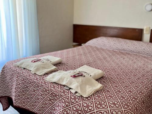 ein Bett mit zwei Handtüchern darüber in der Unterkunft Hotel Lobato in Paysandú