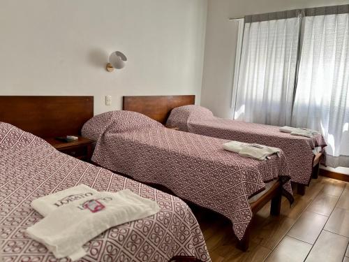 ein Krankenhauszimmer mit 2 Betten und Decken in der Unterkunft Hotel Lobato in Paysandú