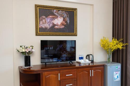 una habitación con TV y una pintura en la pared en Queen Garden Hotel & Apartment, en Vung Tau