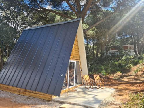 a small house with a blue roof and chairs at FALCOARIA de Santa Efigenia in Setúbal