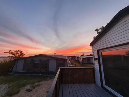 a house with a deck with a sunset in the background at Kite House Chałupy in Władysławowo