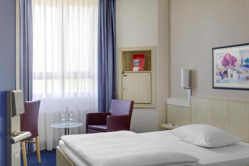 A bed or beds in a room at IntercityHotel Kassel