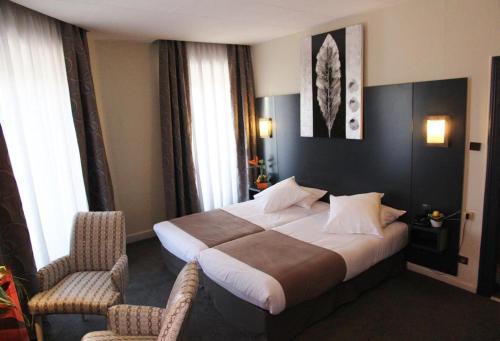 una camera d'albergo con un letto e due sedie di Hôtel Le Bristol Strasbourg Gare a Strasburgo