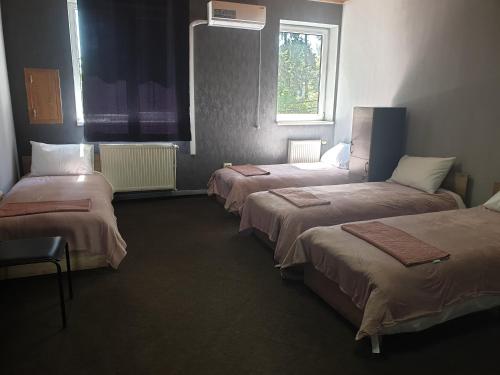 a room with three beds and a window at Мандри Хостел in Uzhhorod