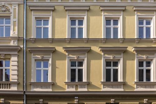 une rangée de fenêtres sur un bâtiment jaune dans l'établissement Felicjanek 15 - by Upstairs, à Cracovie