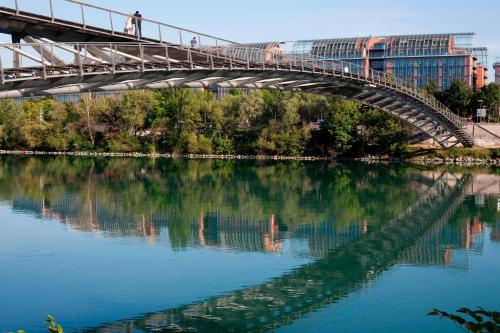 a bridge over a river with people walking on it at Lyon Marriott Hotel Cité Internationale in Lyon