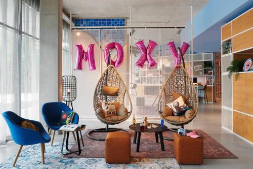 a room with three chairs and v signs on the wall at Moxy Sophia Antipolis in Biot