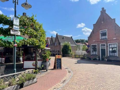 een geplaveide straat in een stad met een gebouw bij De Scheve Deur in Vollenhove