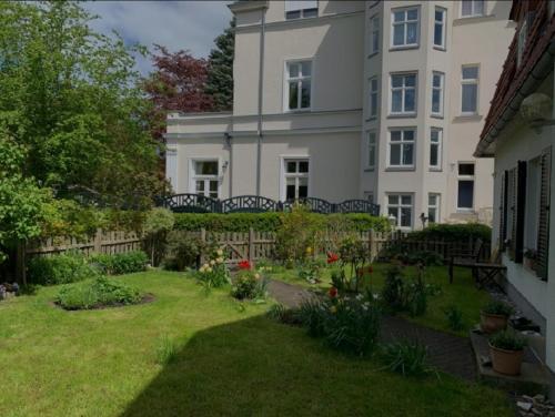 uma grande casa branca com um jardim em frente em Haus mit 110qm und Garten 150m zum Wasser em Stralsund