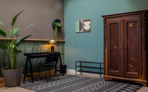 a room with a potted plant and a wooden door at Hotel Botanique Breda in Breda