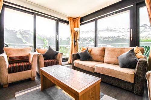 福勒恩Penthouse 3-bedroom apartment, mountain views, large terrasse, piste access的带沙发、桌子和窗户的客厅