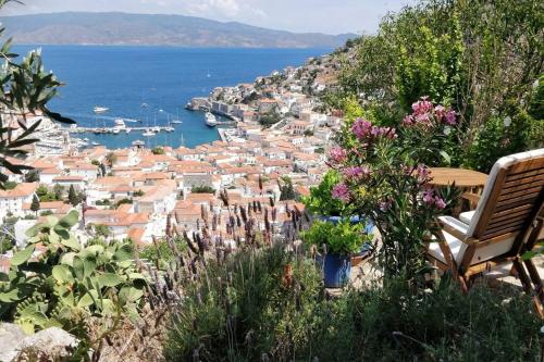 un banco sentado en una colina con vistas a una ciudad en Braxos A beautiful rocky place, en Hydra